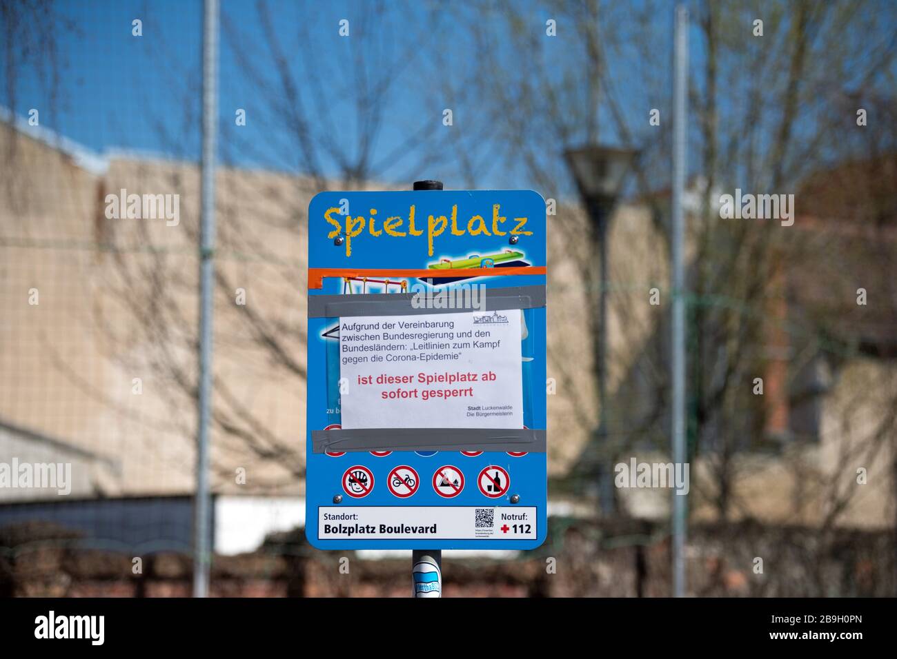 Luckenwalde, Germany. 24th Mar, 2020. On a sign next to a volleyball court, there is a notice stating that the playground is closed due to the Corona pandemic. The city wants to enforce the ban on crowds in parks and public areas by marking them with barrier tape. Credit: Soeren Stache/dpa-Zentralbild/dpa/Alamy Live News Stock Photo