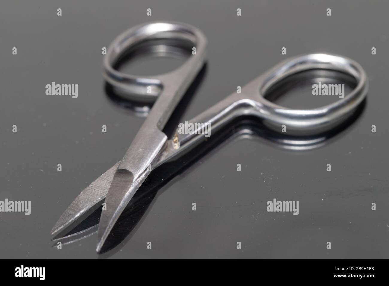 Close-up of open manicure scissors with a reflection. Stock Photo