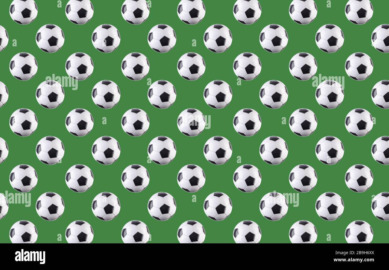 Seamless pattern of balls. Black and white soccer balls flying in the air, isolated on green background. Minimalistic concept of sports Stock Photo