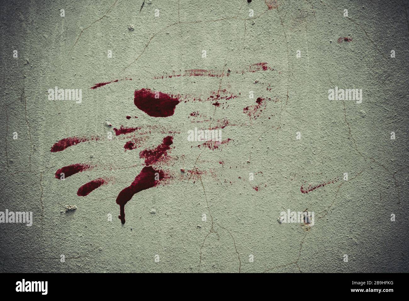 Red blood like hand shape stuck on the grunge wall background in abandoned house. Halloween haunted scene and spooky concept. Stock Photo