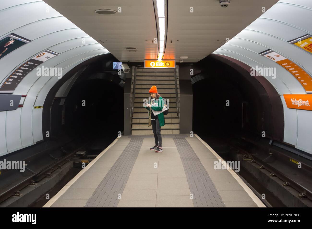 A young lady using her phone one the platform of Bridge Street underground subway station in Glasgow, Scotland, UK Stock Photo