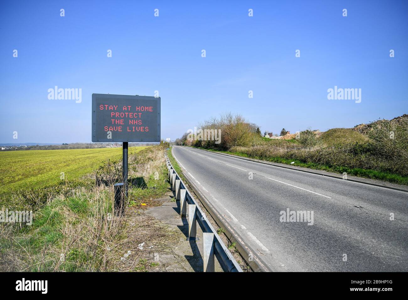 A matrix road sign on the A367 into Bath advises motorists to stay at home to protect the NHS and save lives the day after Prime Minister Boris Johnson put the UK in lockdown to help curb the spread of the coronavirus. Stock Photo