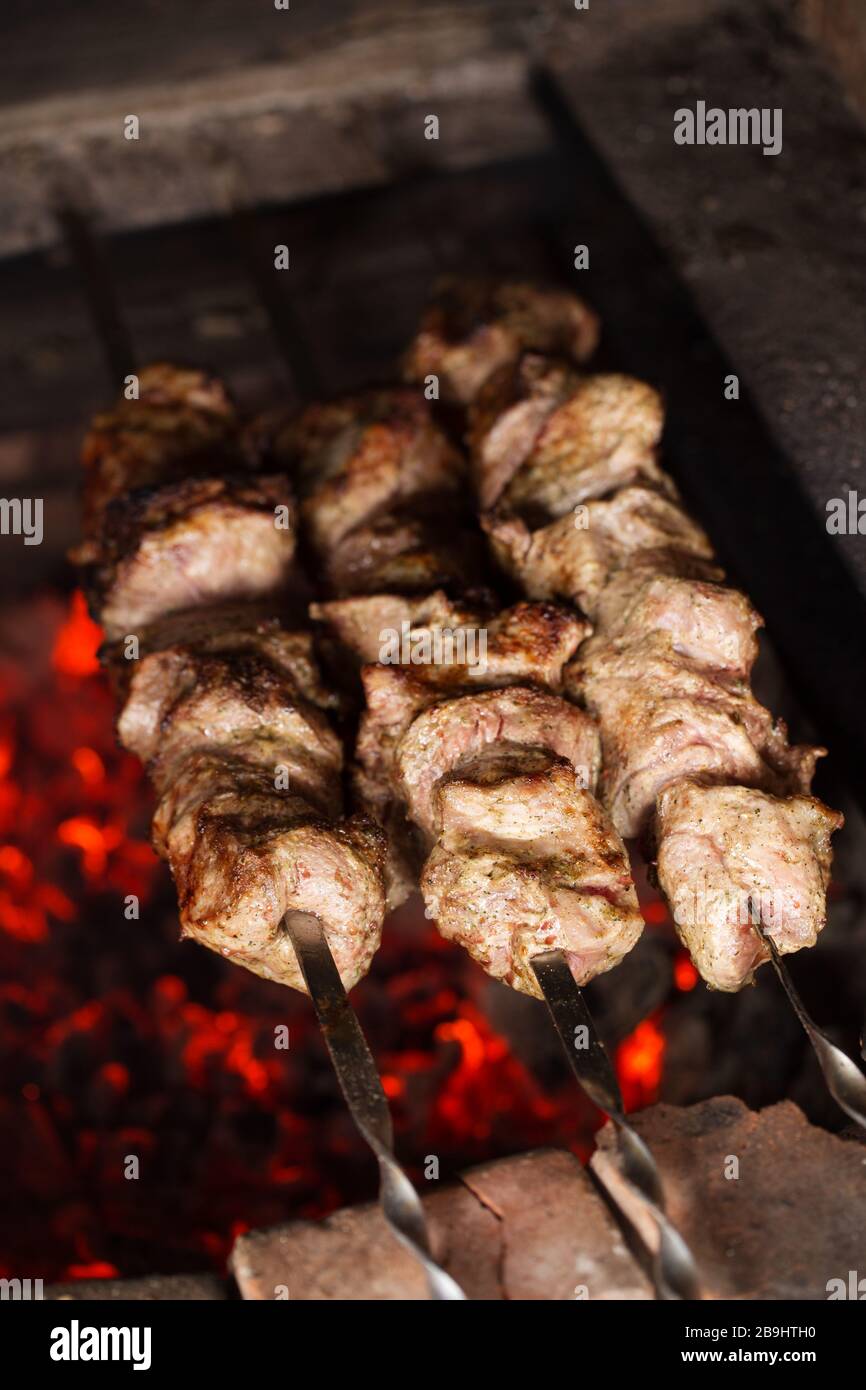 Roasting pork meat on skewers. Barbeque on charcoal. Cooking shashlik Stock Photo