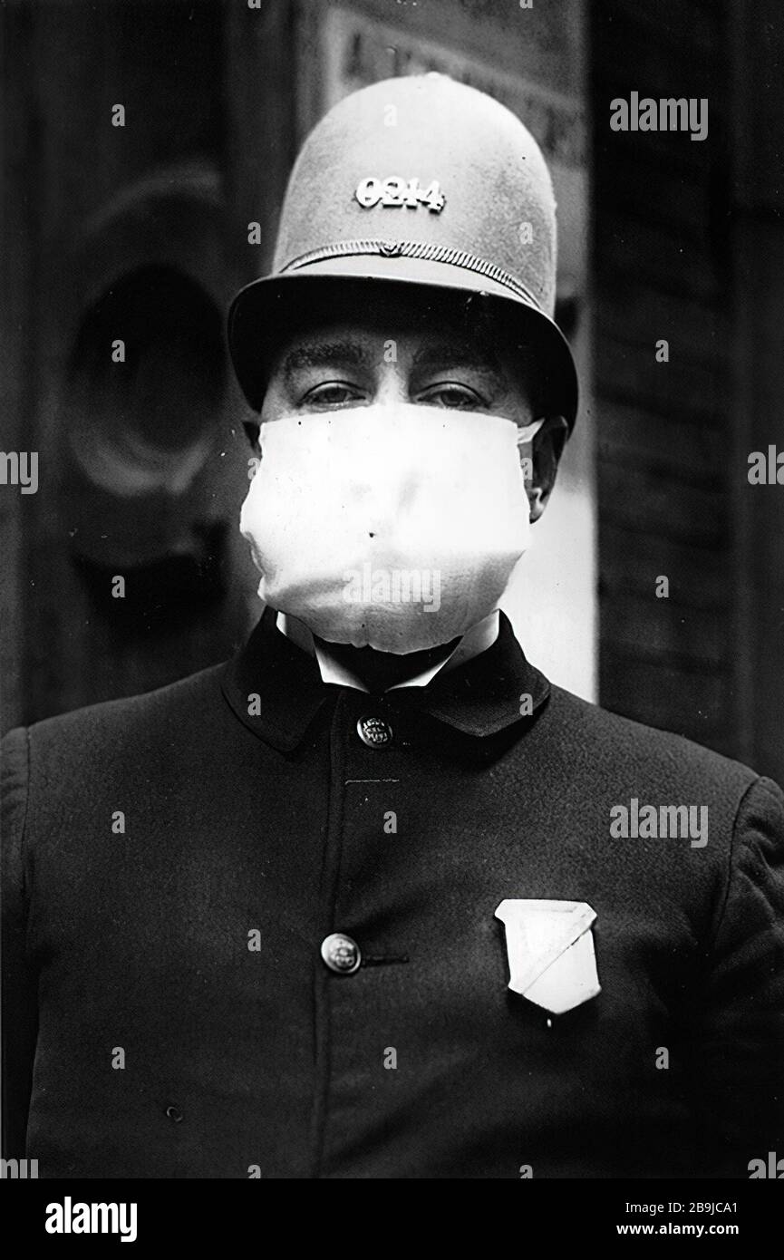 A New York City police officer wears a flu mask while on duty, October 7, 1918 1918-1919. An epidemic of 'Spanish Flu' spread around the world. At least 20 million died, although some estimates put the final toll at 50 million. Stock Photo