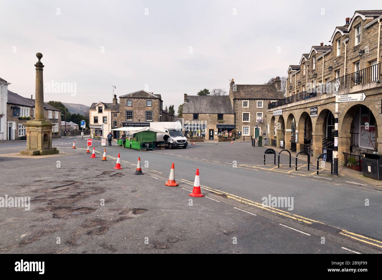 Settle, North Yorkshire, UK. 24th Mar 2020. The nearly empty market place on Market Day in Settle on the edge of the Yorkshire Dales National Park. Few stalls were in evidence of day 1 of the major shutdown due to the Coronavirus crisis.  Credit: John Bentley/Alamy Live News Stock Photo