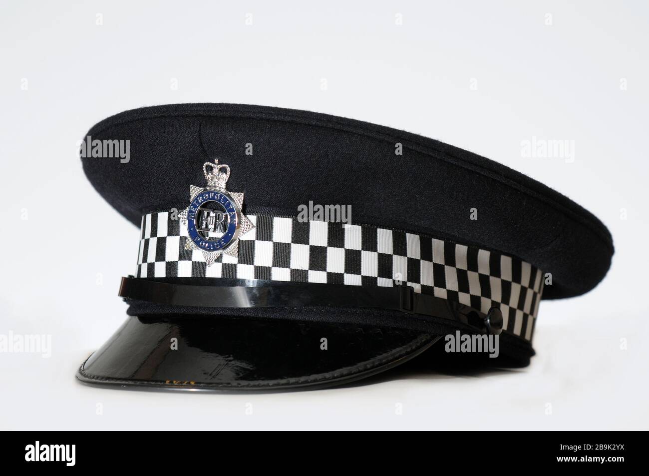 Real British Metropolitan Policeman hat / helmet on plain white background with close up detail of badge Stock Photo