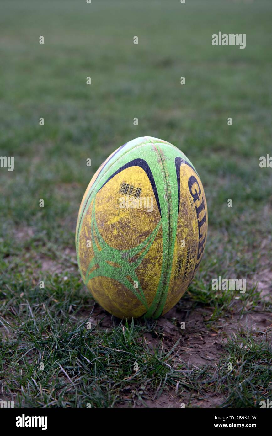 A Dirty Used Full Sized Gilbert Rugby Ball Is Placed On End In Muddy Field Waiting A Dirty Used Full Sized Gilbert Rugby Ball Is Placed On End In Muddy Field Waiting