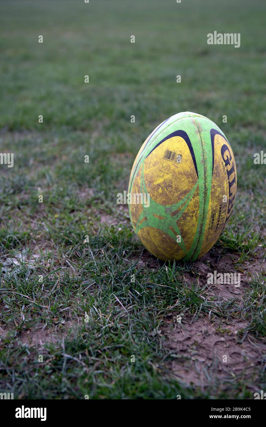 A Dirty Used Full Sized Gilbert Rugby Ball Is Placed On End In Muddy Field Waiting A Dirty Used Full Sized Gilbert Rugby Ball Is Placed On End In Muddy Field Waiting
