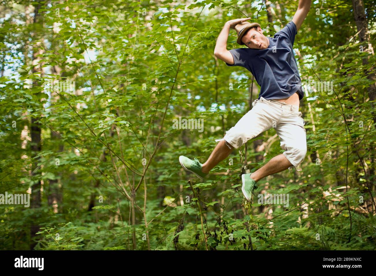 Young man jumping in midair in a forest Stock Photo