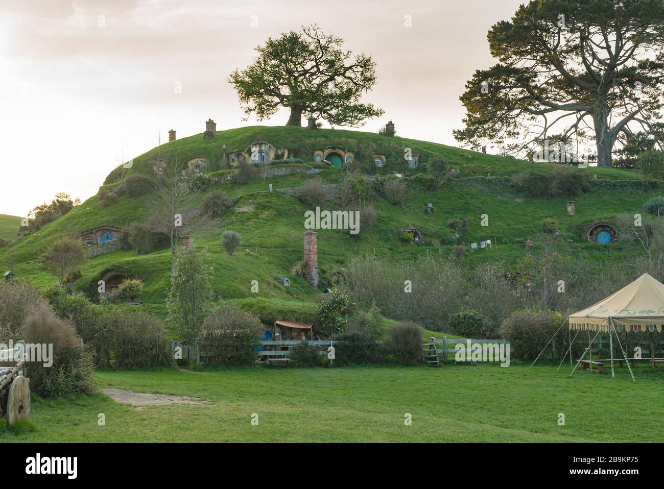The sun sinks behind Bag End in the Hobbiton Movie Set, New Zealand Stock Photo