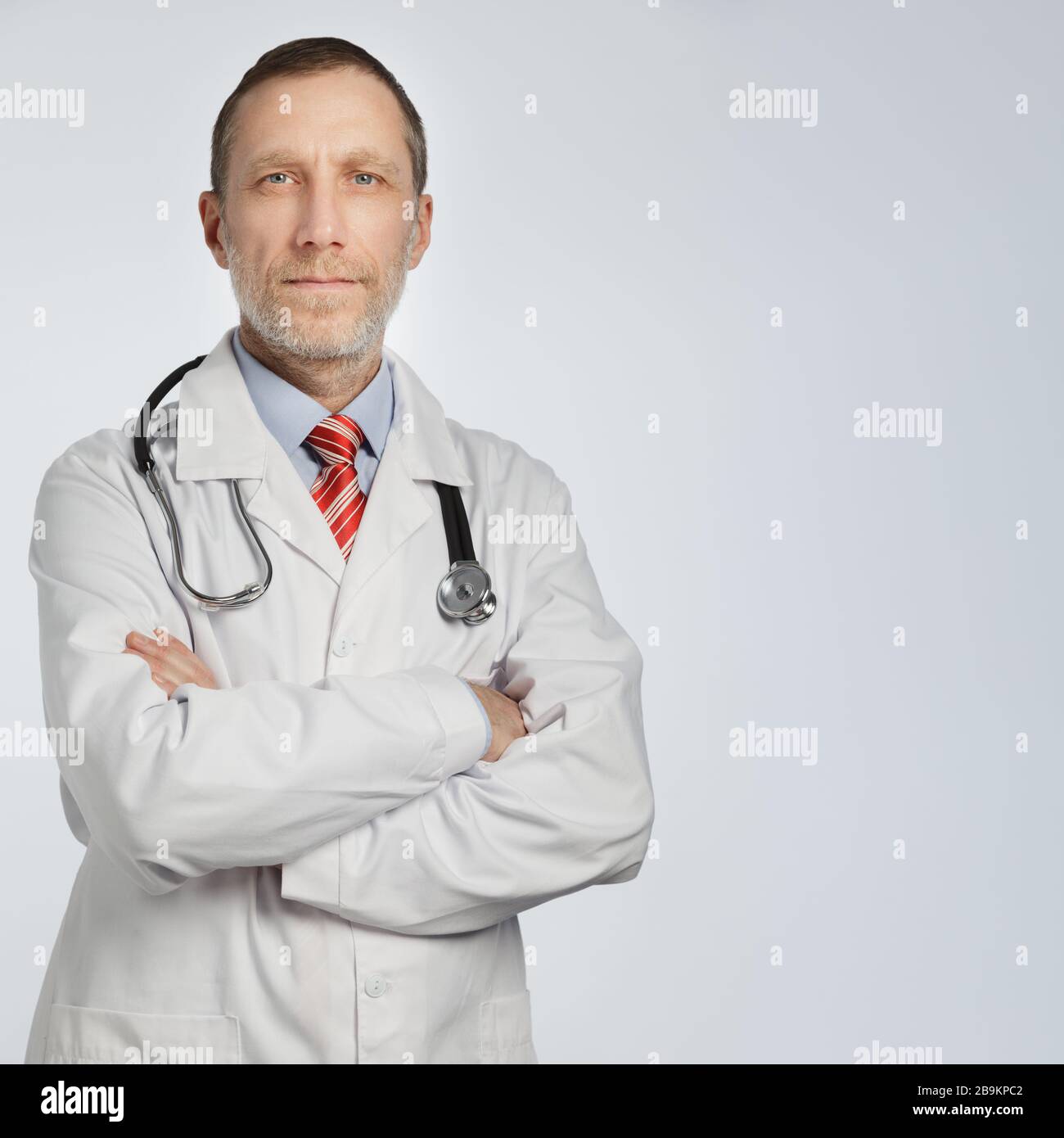 Medical doctor portrait on white background with space for text. Phonendoscope on the shoulders. Stock Photo