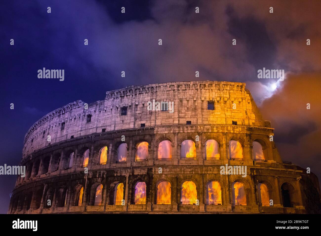 The Colosseum at night with a full moon in long exposure with trails and ghost effect Stock Photo