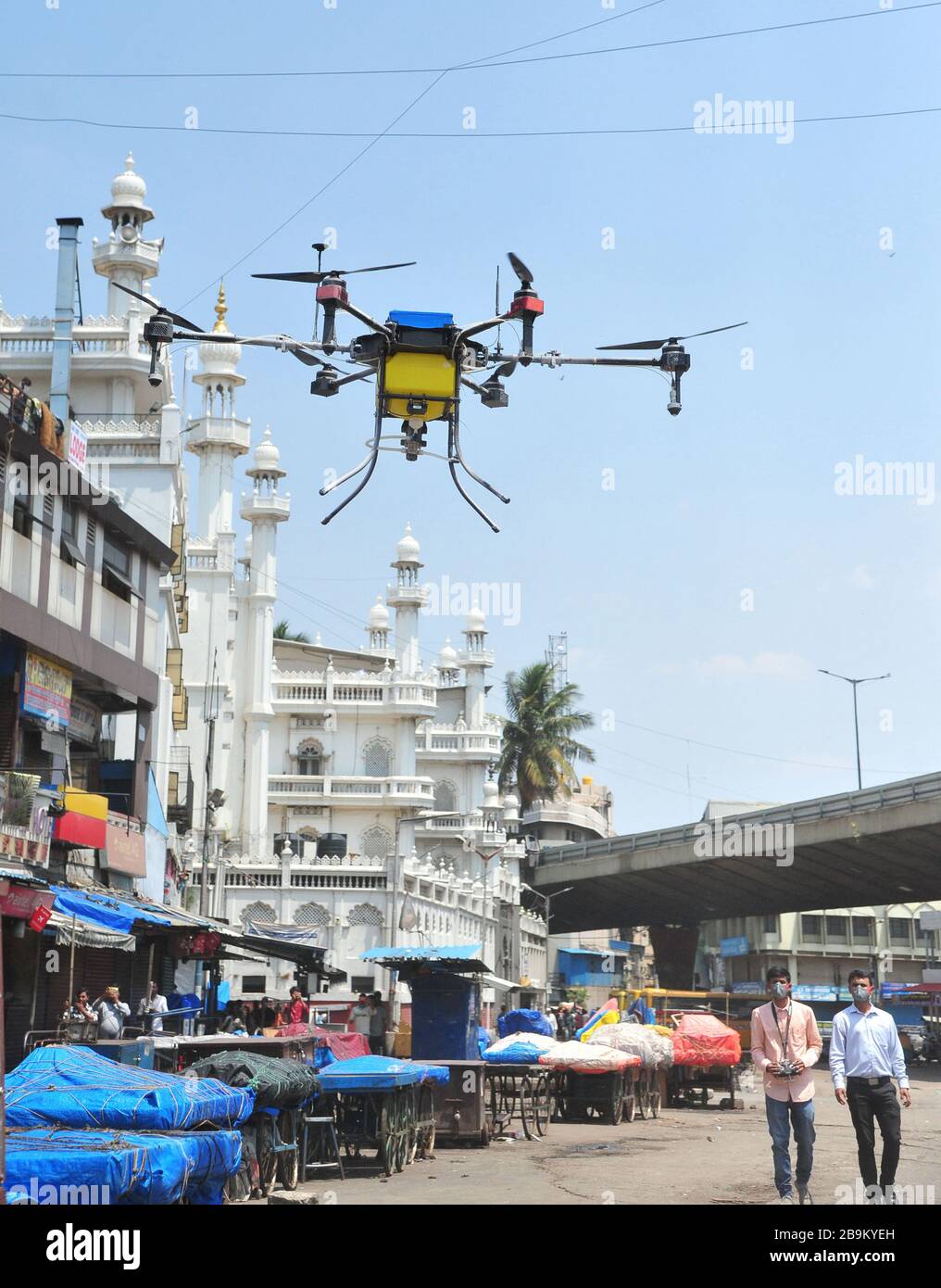 Bangalore, India. 24th Mar, 2020. Indian private company workers fly a drone to spray disinfectant in Bangalore, India, March 24, 2020. The number of confirmed COVID-19 cases in India has reached 519, India's federal health ministry said Tuesday evening. Credit: Str/Xinhua/Alamy Live News Stock Photo