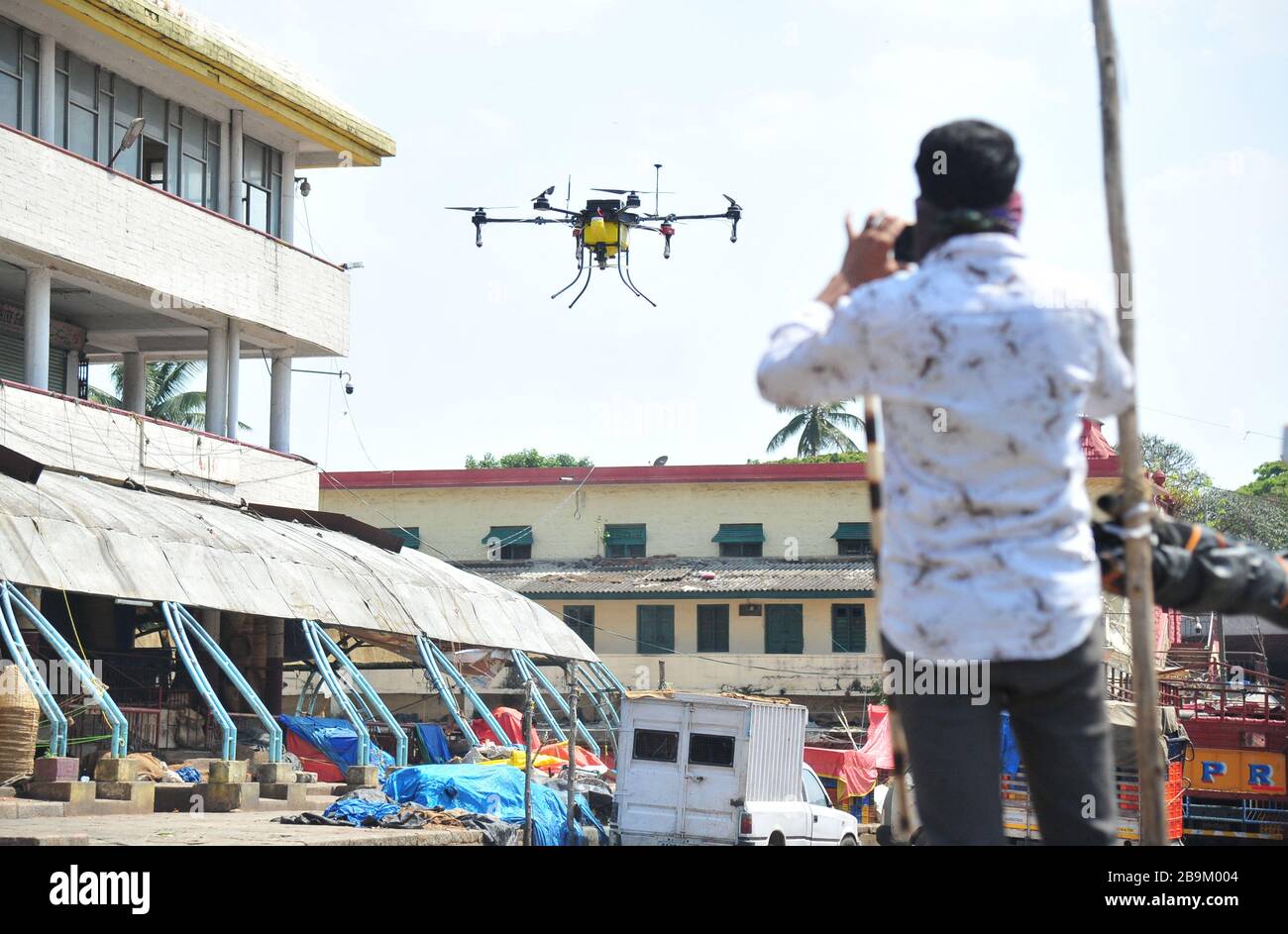 Bangalore, India. 24th Mar, 2020. Indian private company workers fly a drone to spray disinfectant in Bangalore, India, March 24, 2020. The number of confirmed COVID-19 cases in India has reached 519, India's federal health ministry said Tuesday evening. Credit: Str/Xinhua/Alamy Live News Stock Photo