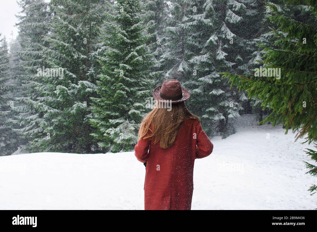 Girl looking on mountain view wearing hat and coat Stock Photo