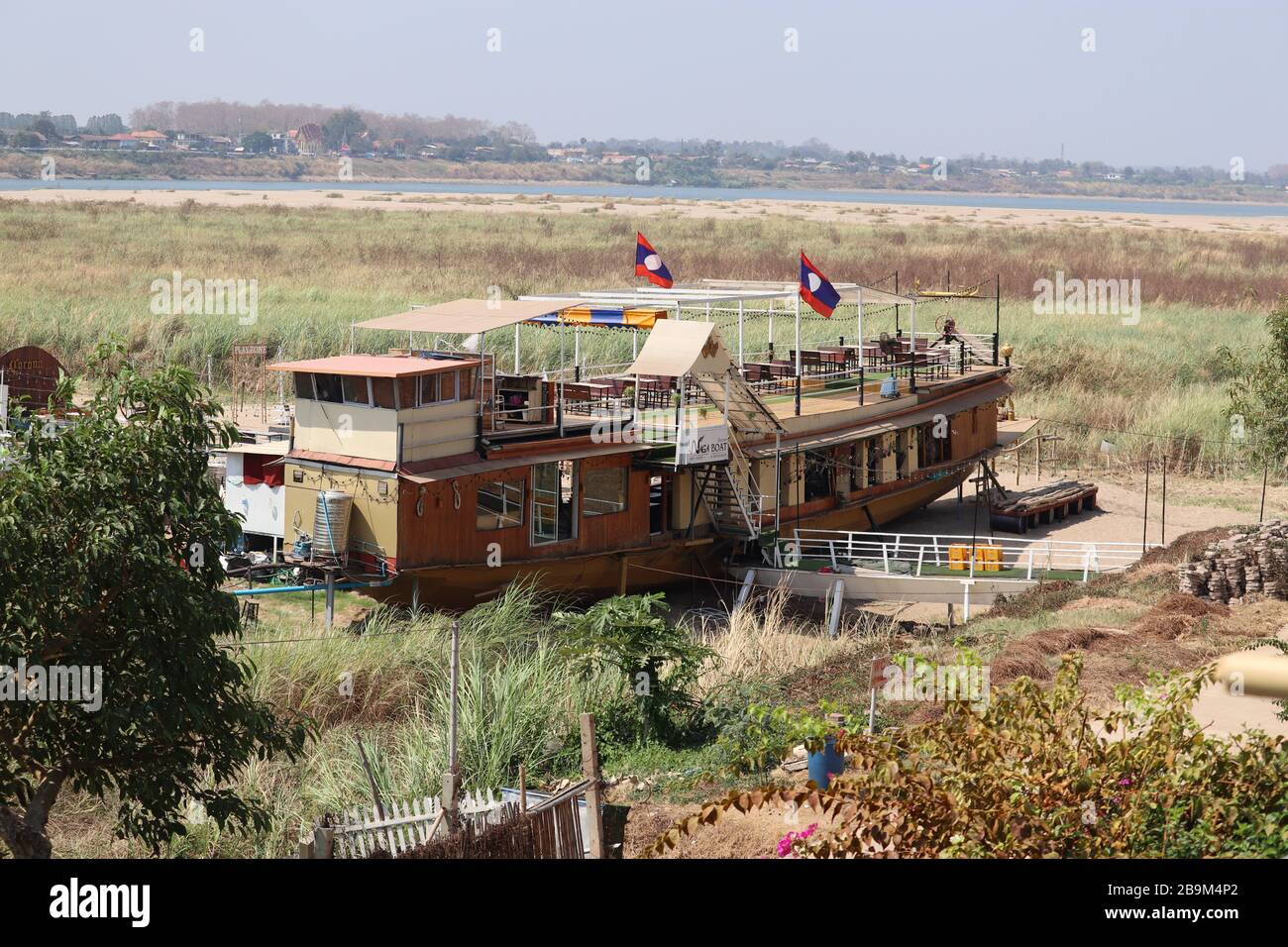 A JUNK BOAT MOORED NEAR THE MEKONG RIVER ,TURNED INTO A RESTAURANT IN VIENTIANE LAOS. Stock Photo