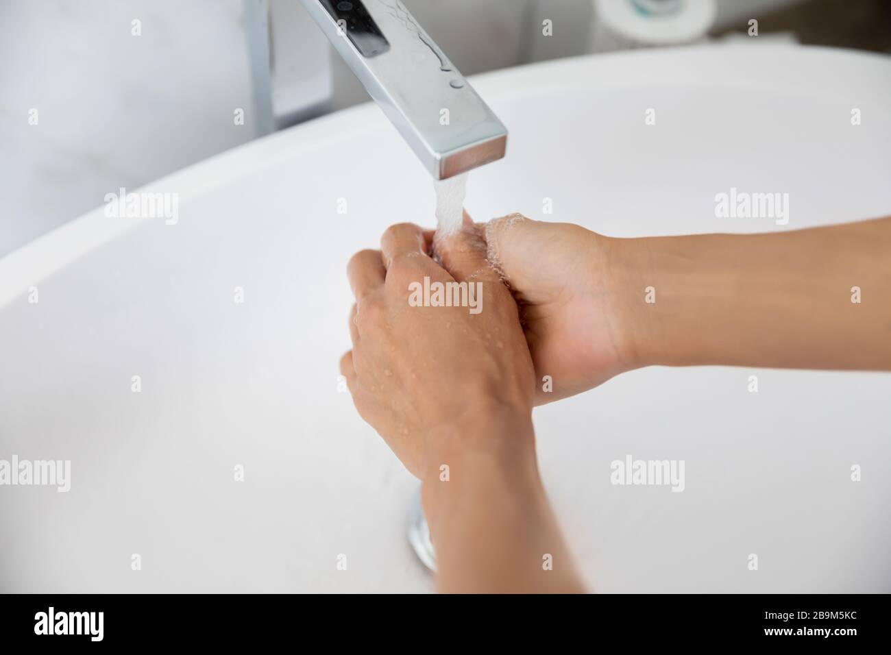 Closeup woman cleans hands using antibacterial agent in toilet room Stock Photo