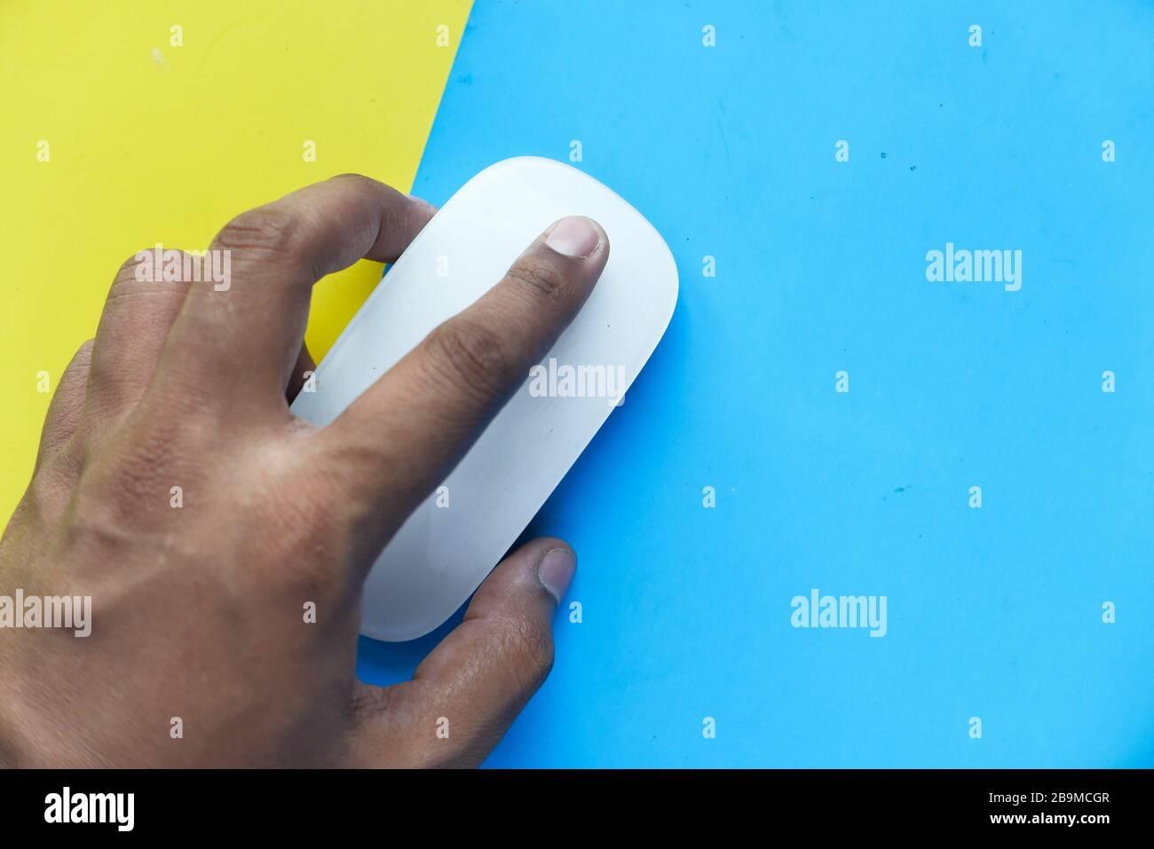man hand use computer muse on color background. Stock Photo