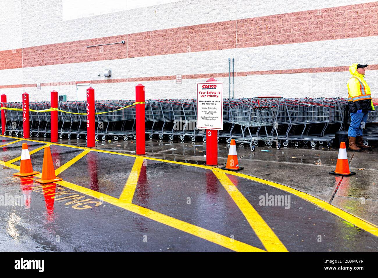 Sterling, USA - March 23, 2020: People by shopping carts at entrance to Costco discount membership club store during Coronavirus Covid-19 outbreak wit Stock Photo