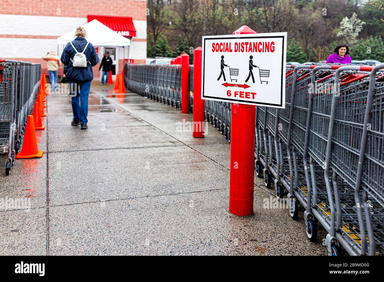 Sterling, USA March 23, 2020 People customer woman by shopping carts at entrance to Costco