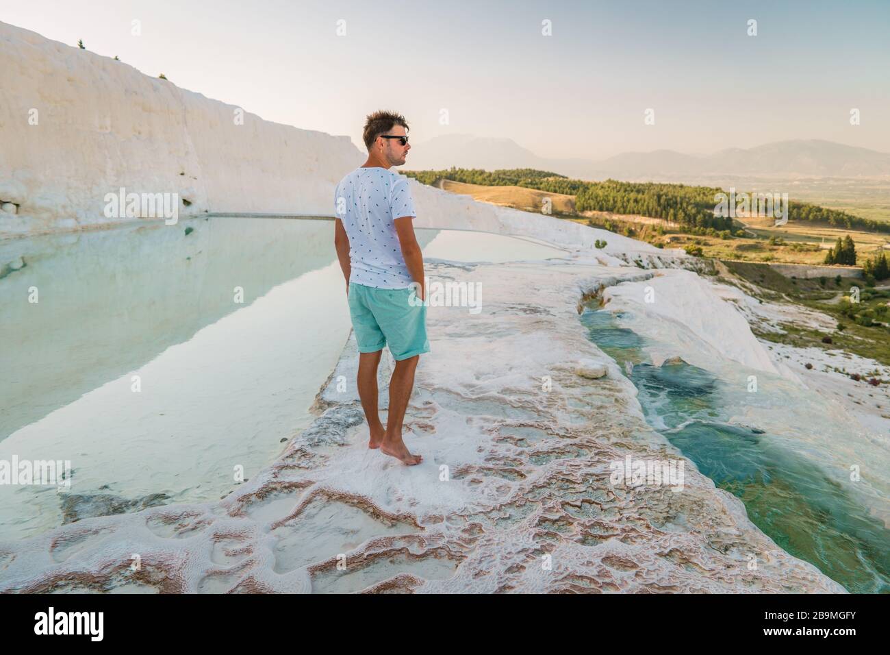 Turkey, Natural travertine pools and terraces in Pamukkale. Cotton castle in southwestern Turkey, man tourist by natural pool Pamukkale Stock Photo