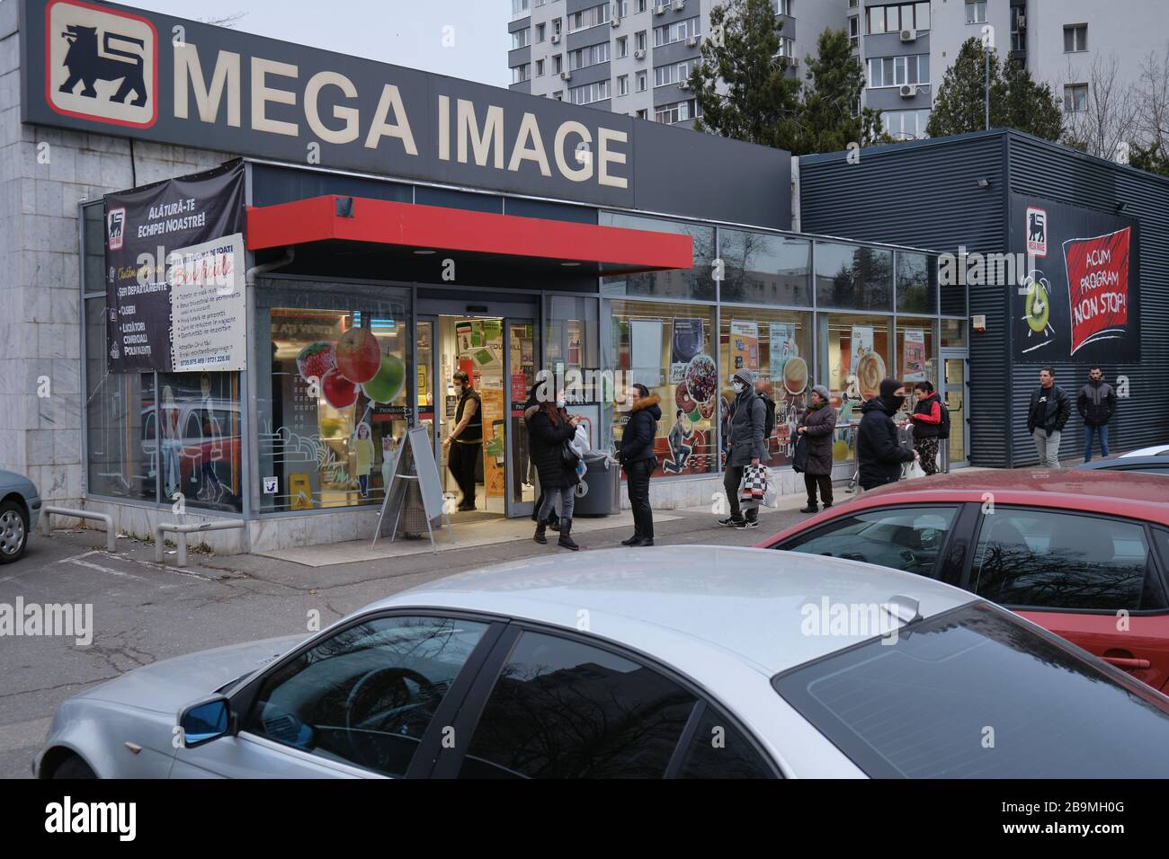 Bucharest, Romania - March 24, 2020: People wait in line in front of a Mega Image supermarket, keeping a safe distance between them, after more strict Stock Photo