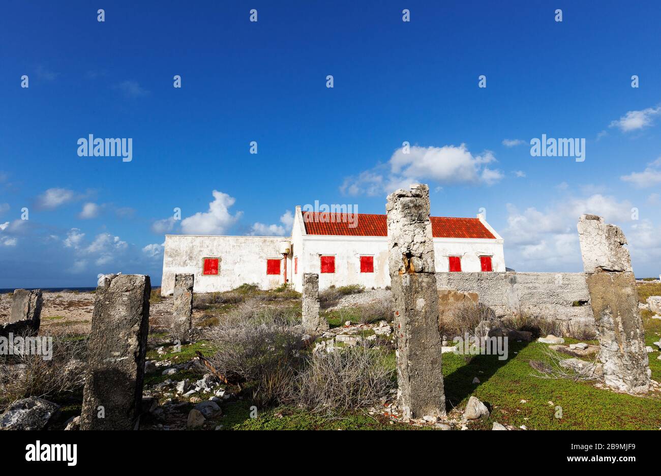 Older ruins and abandoned white house with red window shutters on the coast of Bonaire part of the ABC Islands, Netherlands Antillies, Caribbean Stock Photo