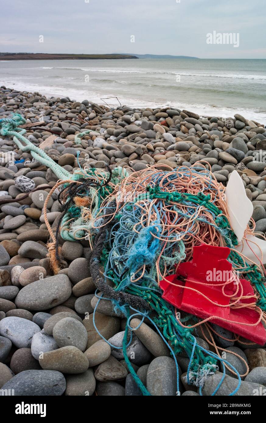 Old fishing nets and plastic waste washed up on the shore of the west