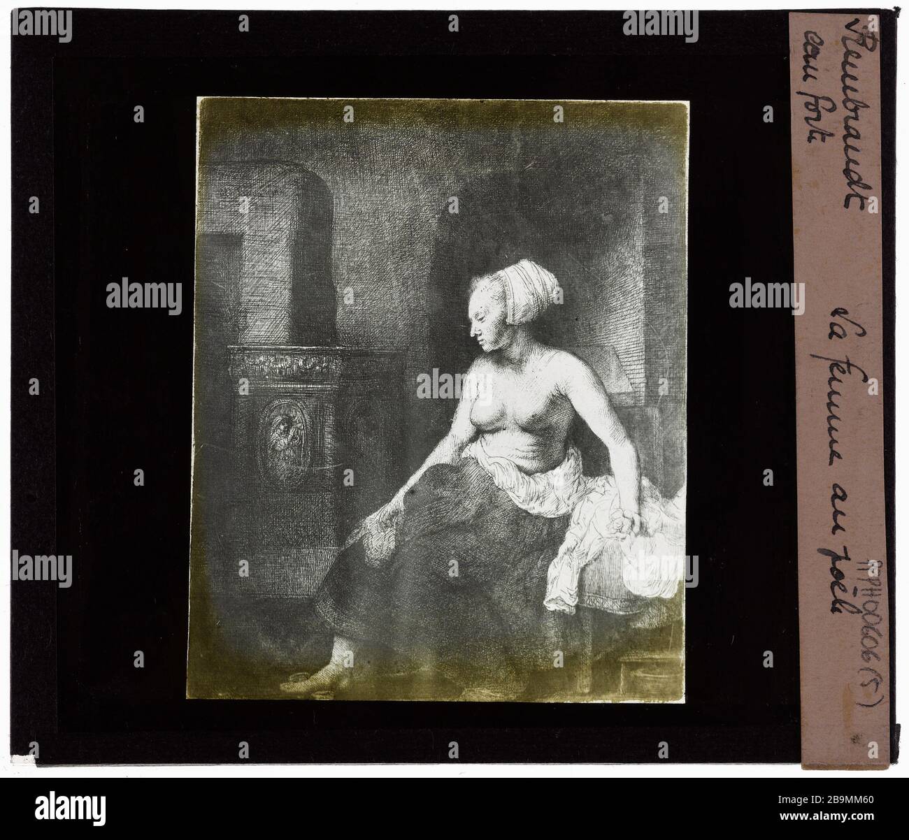 Rembrandt van Rijn (1606-1669), Dutch painter. etchings. The woman at the  stove Rembrandt van Rijn (1606-1669), peintre hollandais. Eaux fortes. "La  femme au poële". Plaque de projection noir et blanc. 1900-1930. Photographie