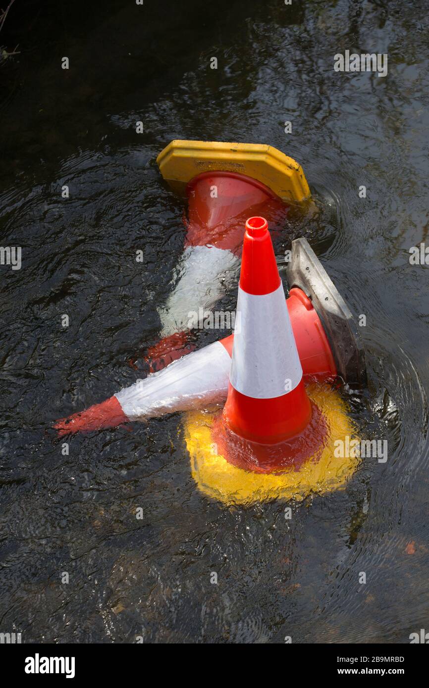 Traffic cones that have been thrown off a bridge from roadworks into the River Stour in Gillingham North Dorset England UK GB Stock Photo