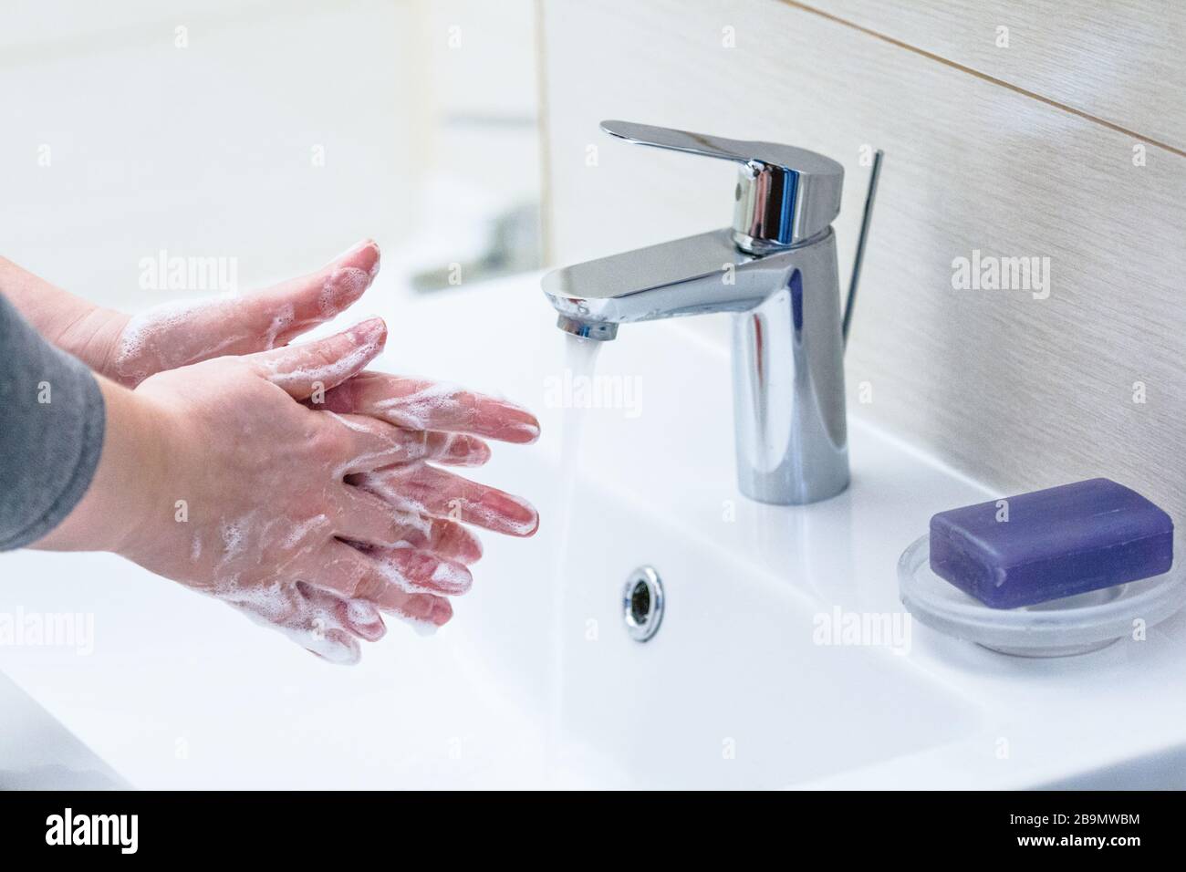 Hand washing with soap over sink in bathroom, closeup. Stock Photo