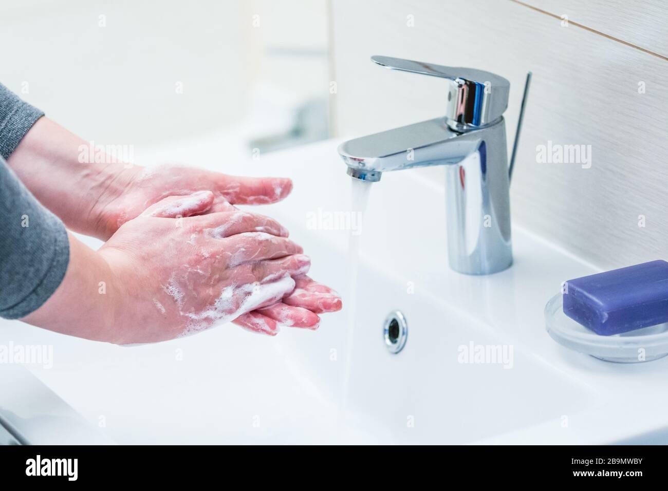 Hand washing with soap over sink in bathroom, closeup. Stock Photo
