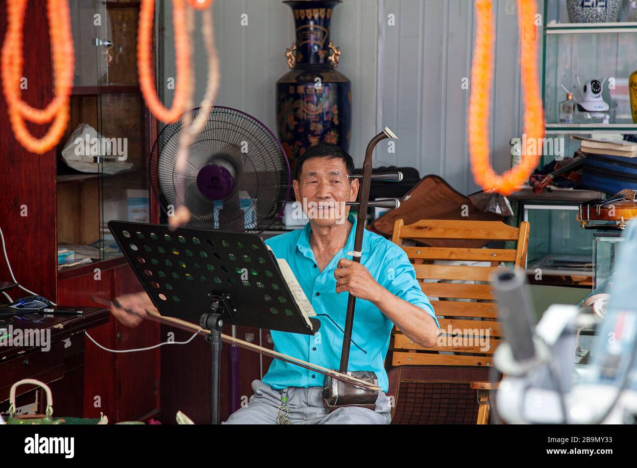 Man playing Erhu traditional Chinese string instrument Chengdu Street Market China Stock Photo