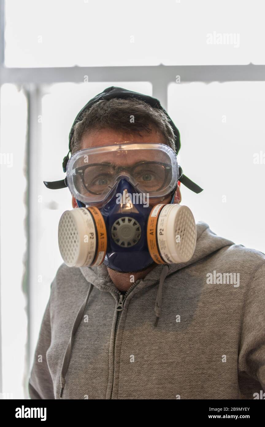 Jewish man wearing a yarmulke in full gas mask and goggles as silly protection against covid-19 corona virus Stock Photo