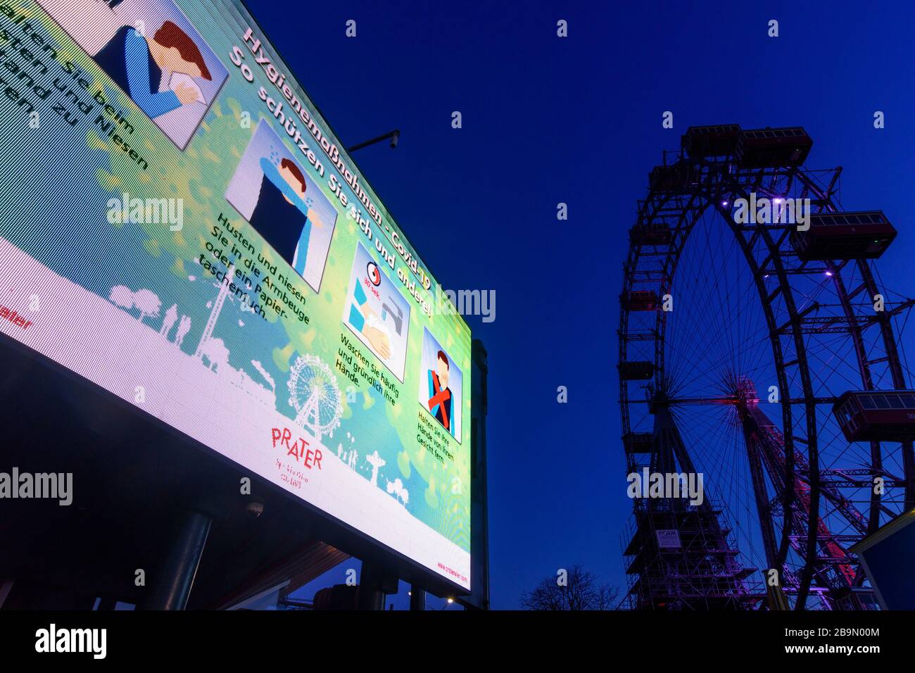 Wien, Vienna: information video wall with information about hygiene measures ('How to protect yourself and others') in German, Ferris Wheel at Prater Stock Photo