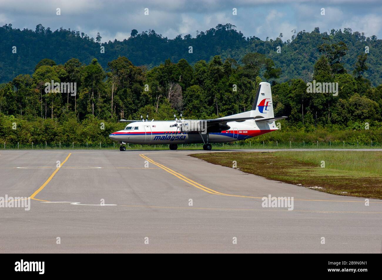 Malaysia Airlines Fokker 50 prop driven aircraft landing at Mulu, Sarawak in the rainforest of Borneo. Stock Photo