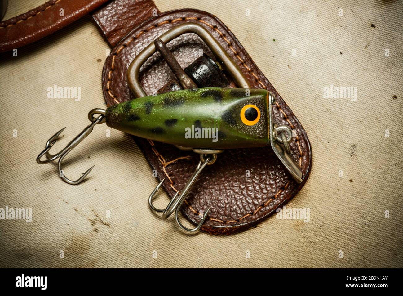 An example of a vintage fishing lure equipped with treble hooks, possibly  made by Woods Mfg, displayed on an old fishing bag. Lures such as these are  Stock Photo - Alamy
