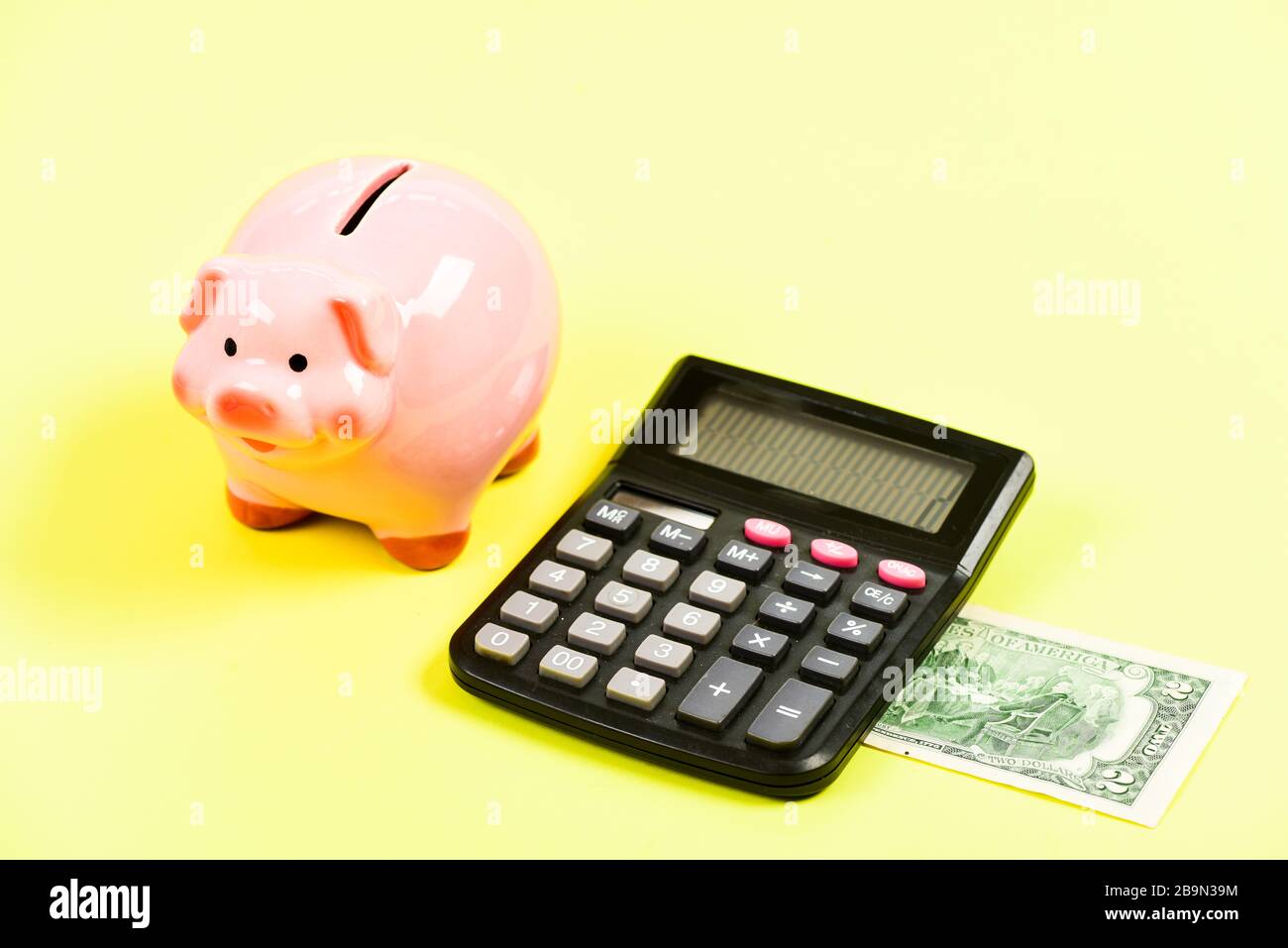 Economics and profit management. Economics and finance. Piggy bank money savings. Piggy bank pink pig and calculator. Exchange rates. Economics and business administration. Credit debt concept. Stock Photo