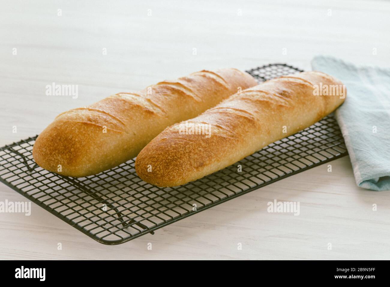 French baguette fresh out of the oven cooling on a rack Stock Photo Alamy