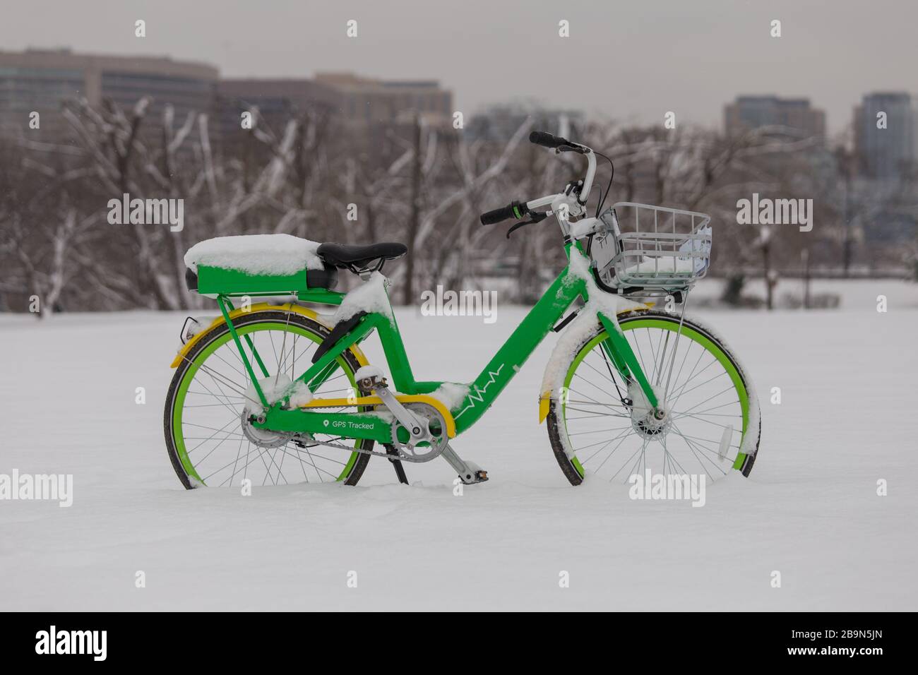 Bike share electronic bicycle covered in snow is left sitting in a parking lot in Washington, D.C. after a snowstorm Stock Photo