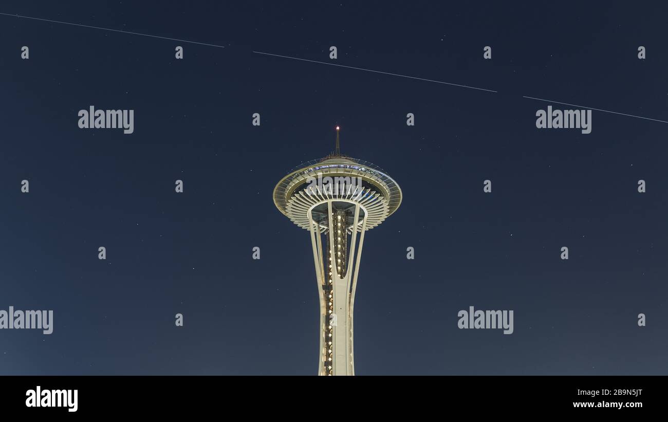 The International Space Station passes high above the Space Needle in Seattle amidst a background of stars in the night sky Stock Photo