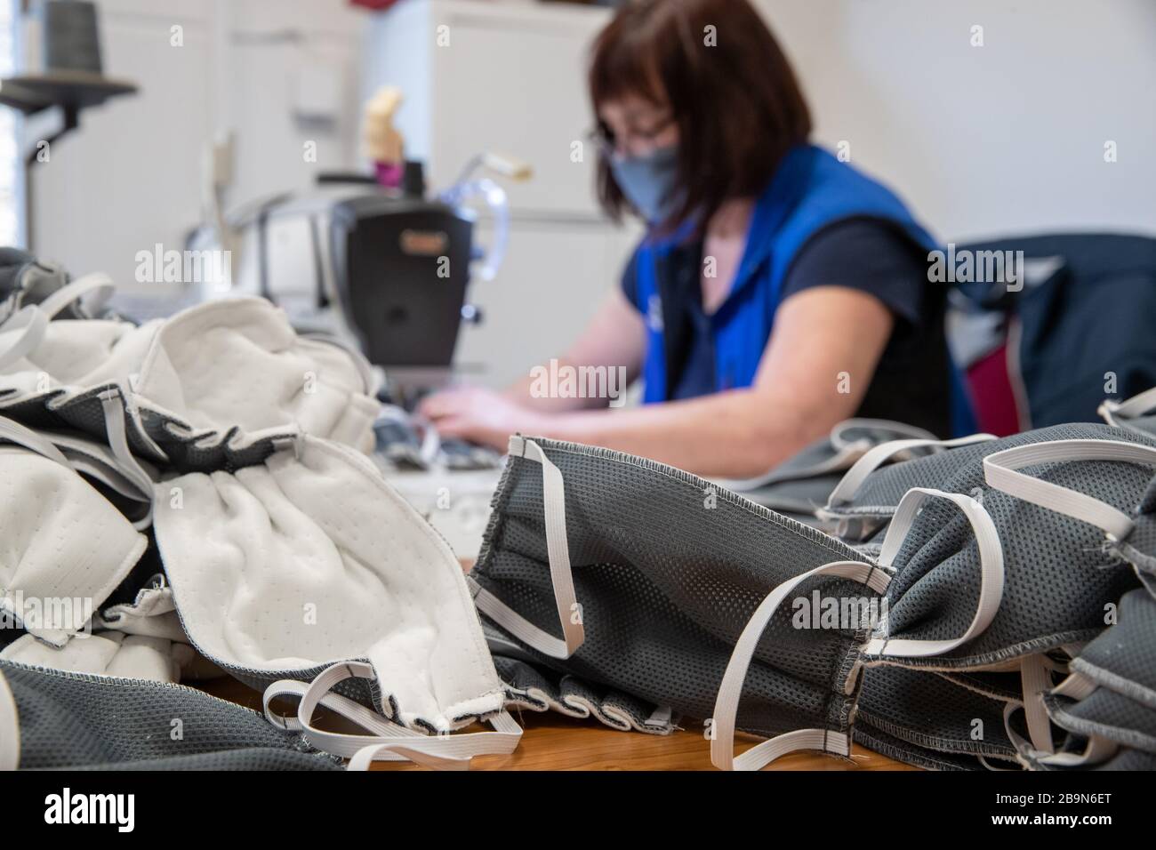23 March 2020, Bavaria, Würzburg: A seamstress of the mattress and foam manufacturer Wegerich, sews mouthguards in the production of the company. Actually the company produces mattresses for mobile homes and care beds. As packaging she uses a special fleece, which lies around the company in rolls and of which surgical masks are also made. Together with a nursing service, Wegerich has developed a protective mask based on this model. (to dpa: protective masks made by the company itself: 'A sign of solidarity') Photo: Daniel Karmann//dpa Stock Photo