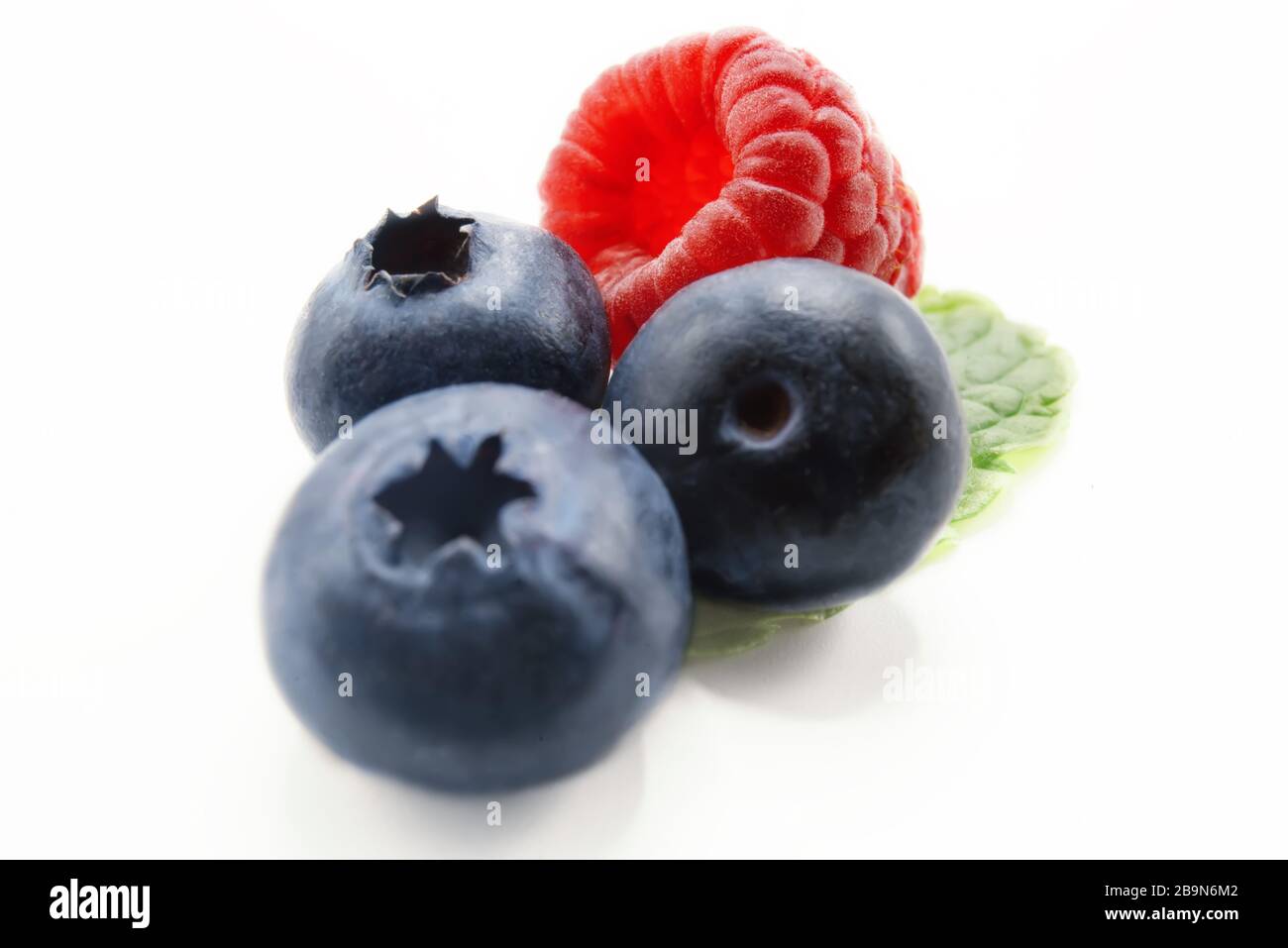 Different fresh summer berries with leaves (raspberry, blueberry) isolated on white background Stock Photo