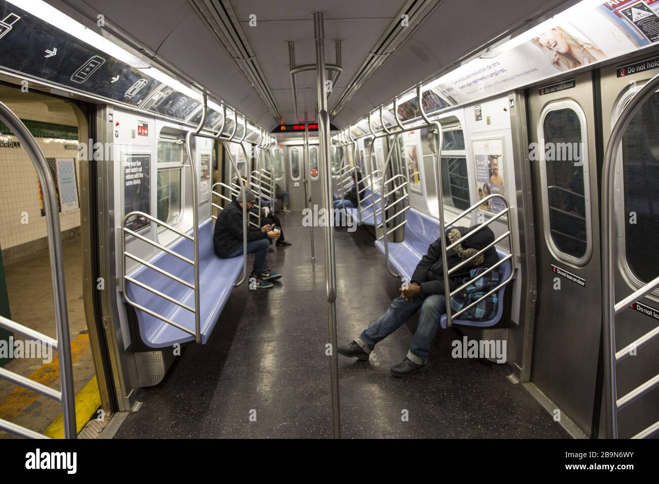 As New York City goes into official lockdown it is not difficult to practice social distancing on subways  as relatively few people are riding the trains. Brooklyn, NY. Stock Photo