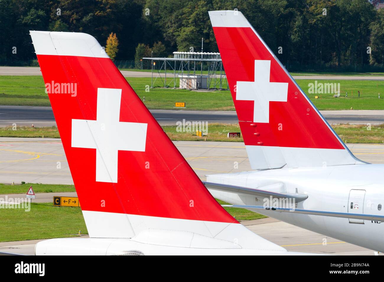 Two Swiss Airlines Boeing 777 tails together at Zurich Kloten Airport. Flag carrier of Switzerland. Livery with red and white cross. Stock Photo