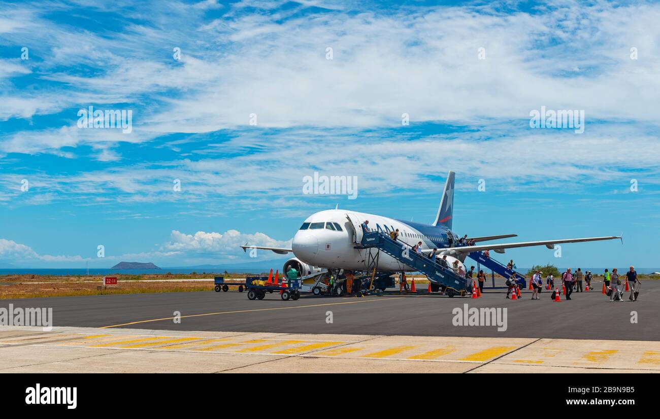 Aircraft and tourists on the tarmac of the airport in Baltra Island, Galapagos islands national park, Ecuador. Stock Photo