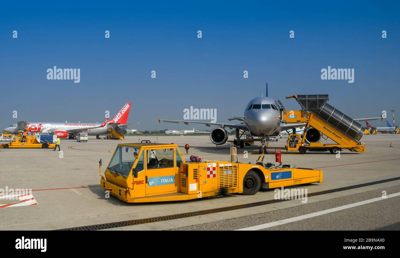 VERONA, ITALY - SEPTEMBER 2018: Aircraft tug parked on the apron in from of an Airbus jet Stock Photo