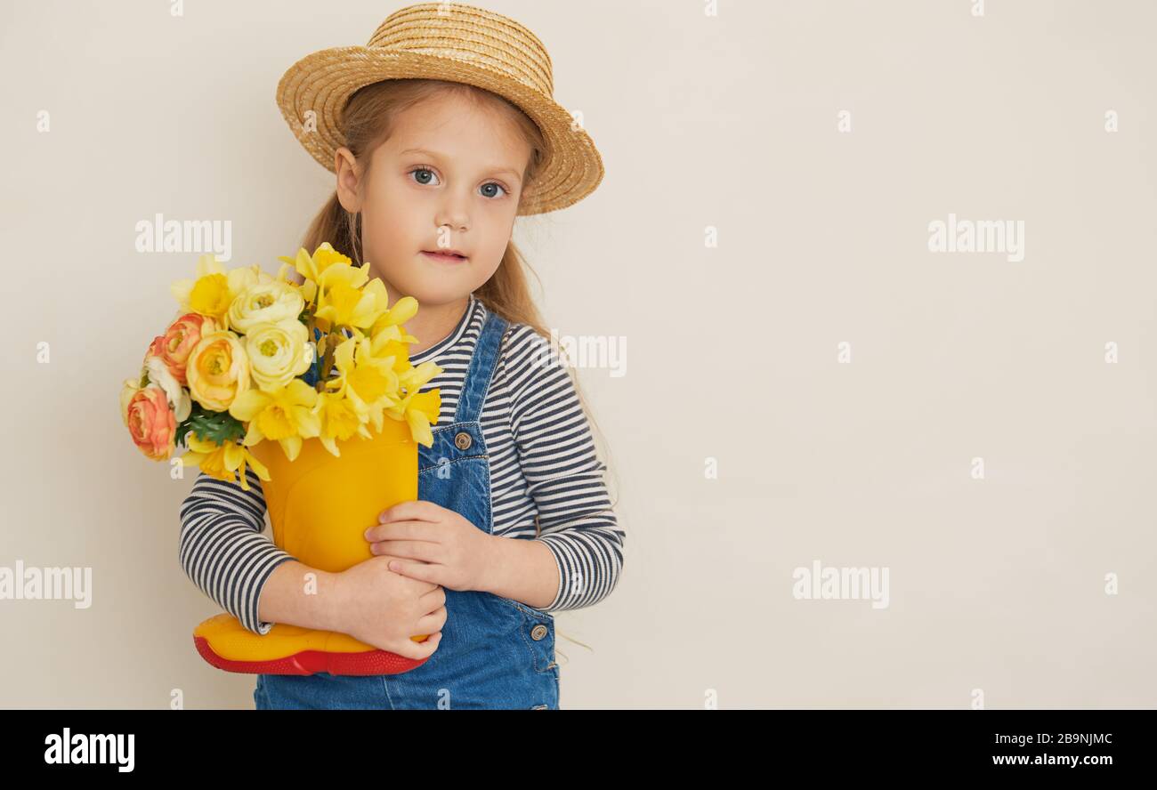 Little surprised child girl in straw hat with a bouquet of yellow ...