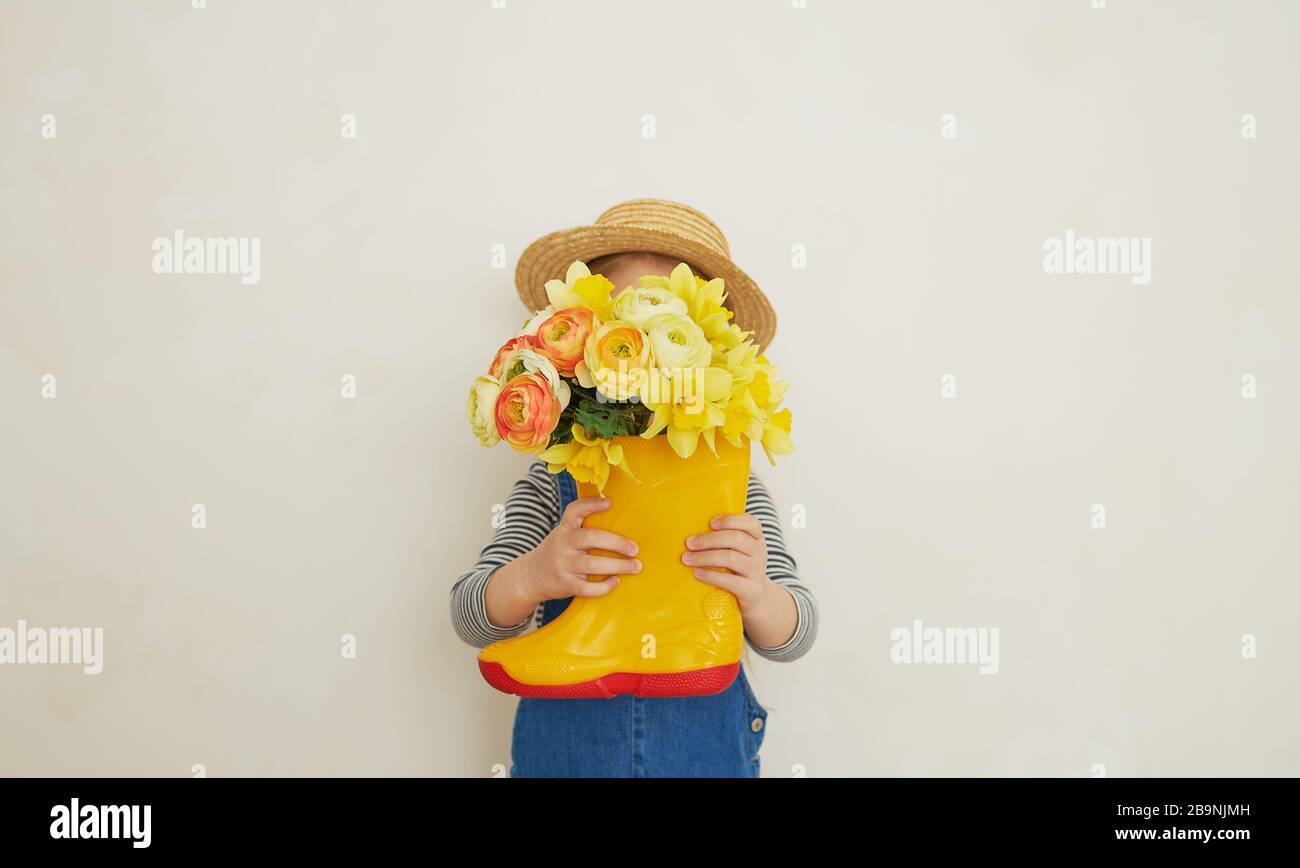 Little surprised child girl in straw hat with a bouquet of yellow ...