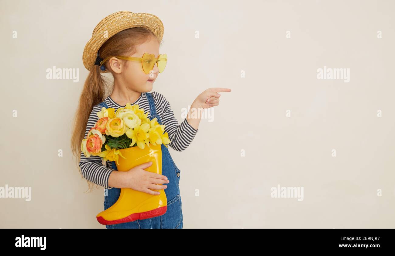 Little surprised child girl in straw hat with a bouquet of yellow ...